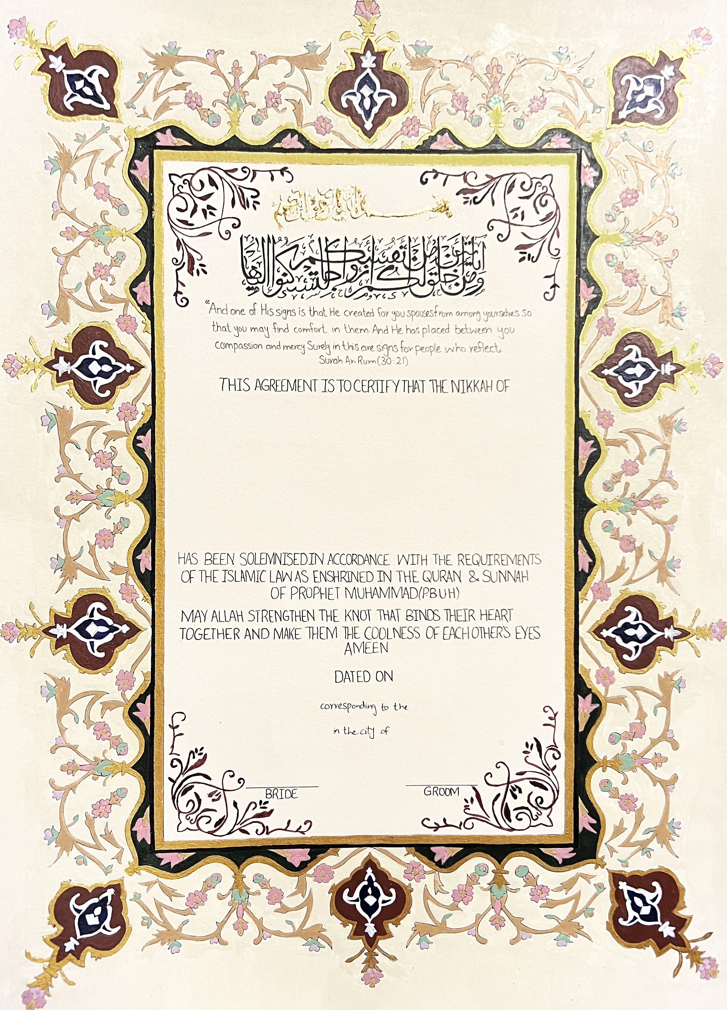 A hand-painted Nikkah Nama by Decorette, photographed straight on: burgundy and navy cartouches, gold-leaf frame and scrolling floral vines around the certificate, with Surah Ar-Rum 30:21 in calligraphy at the head