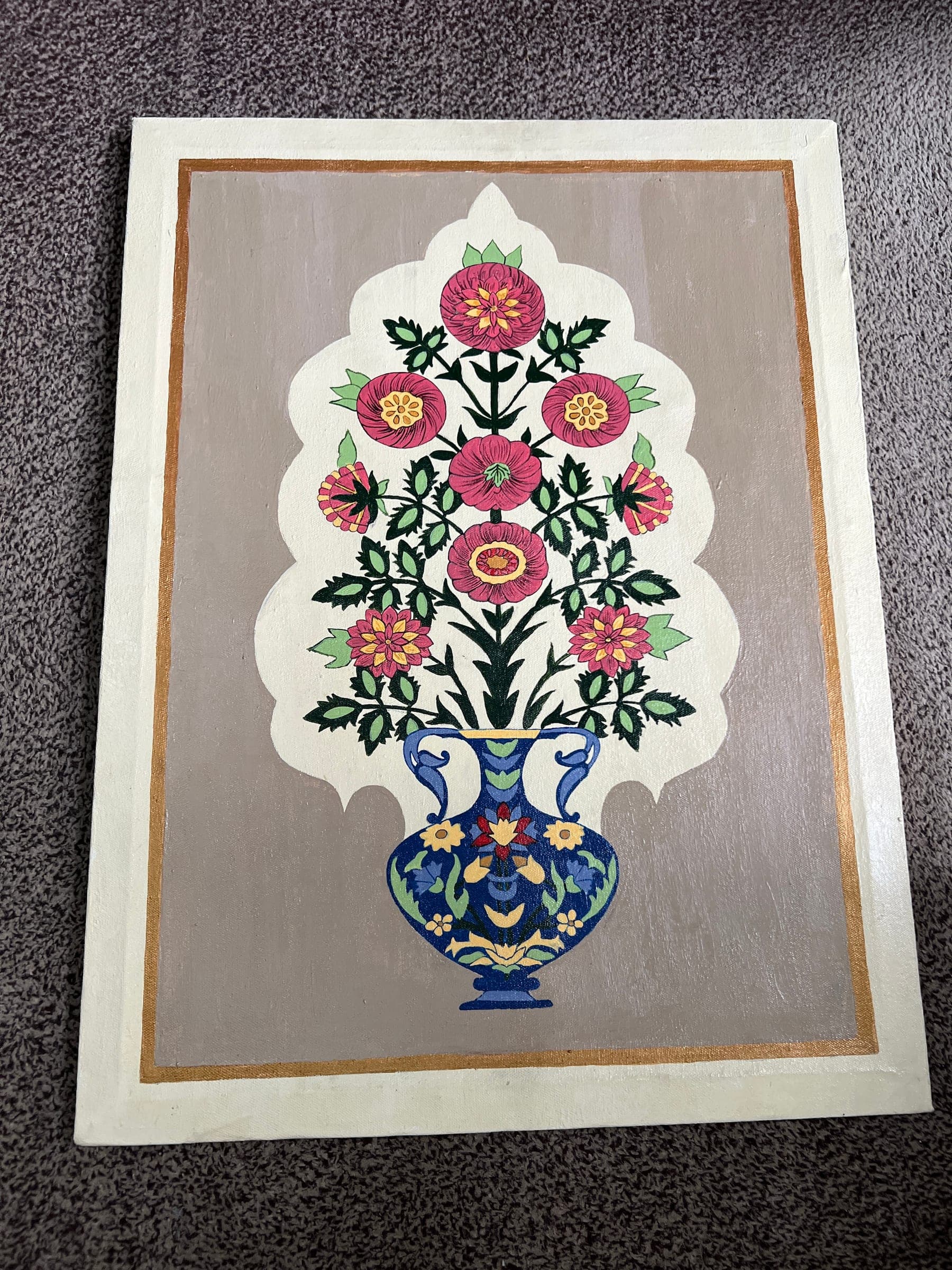 The Mughal floral canvas laid flat: pink and red carnations rising from a cobalt vase on a taupe ground, inside an ivory arch